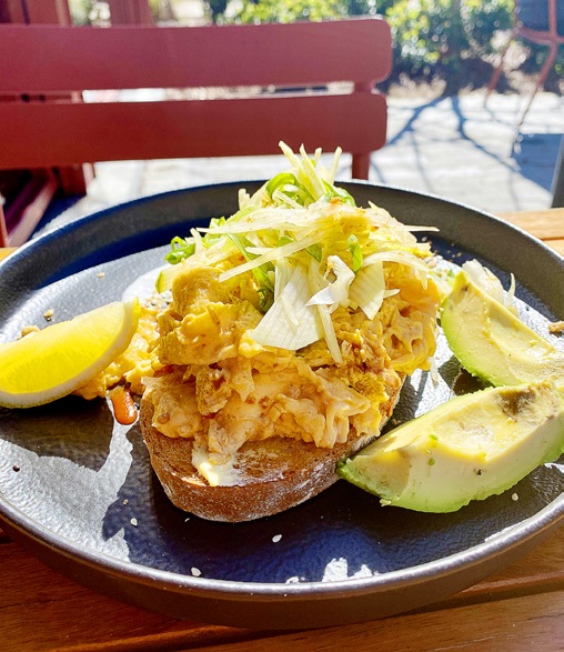Crab toast with avocado on a dark plate