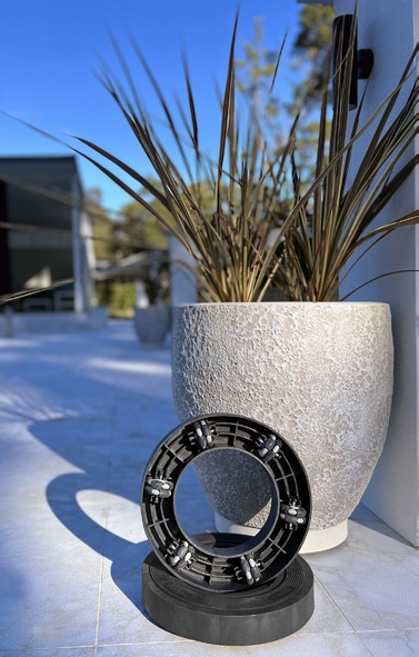 Black Omnia Plant Glider beside a textured pot in sunlight
